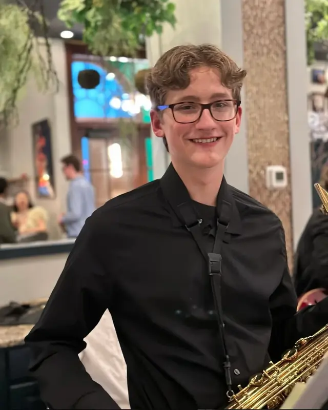 Scholarsjazz saxophonist smiling before a restaurant performance
